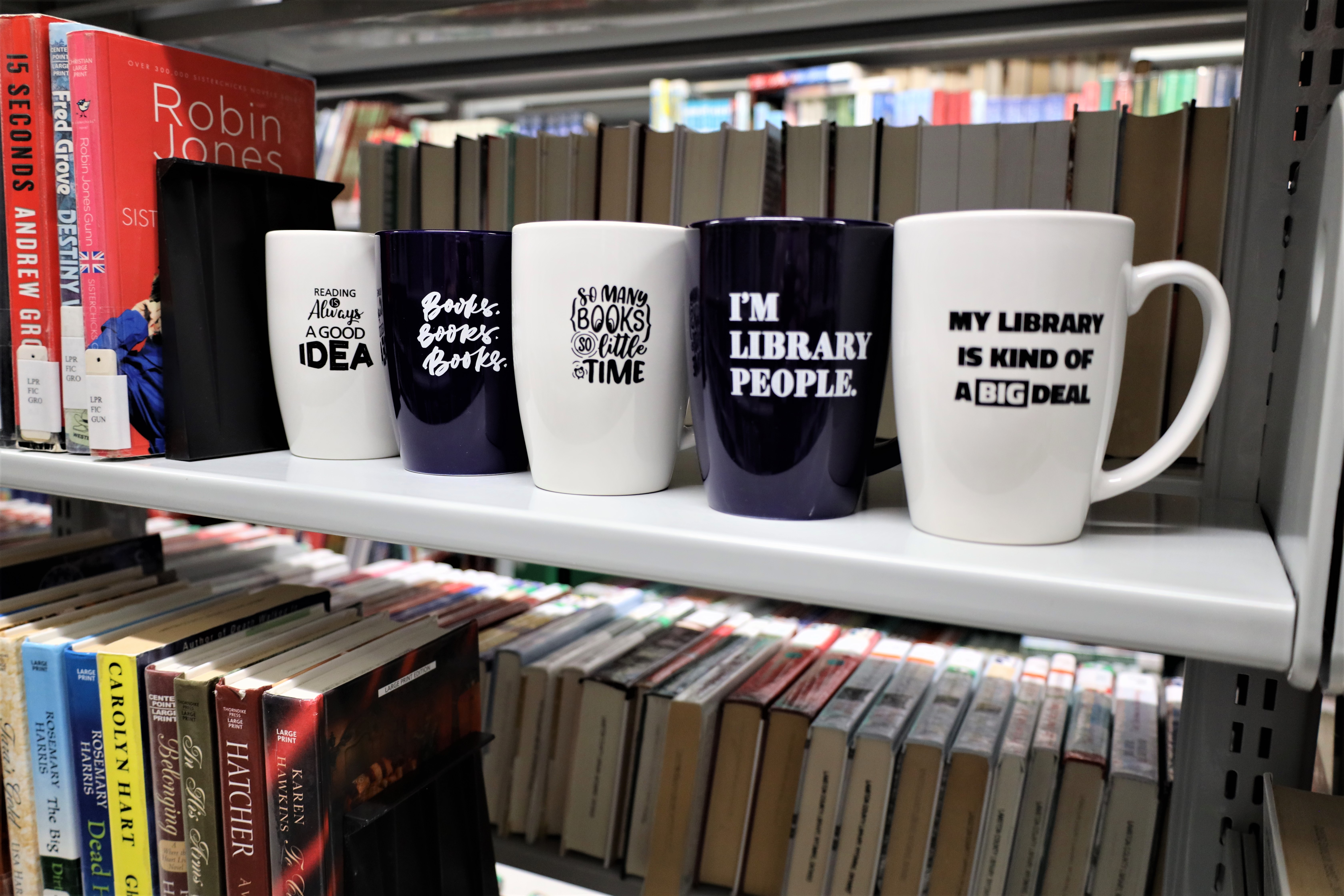 Row of mugs on a bookshelf