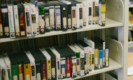 Books on CD's on a shelf in a library.