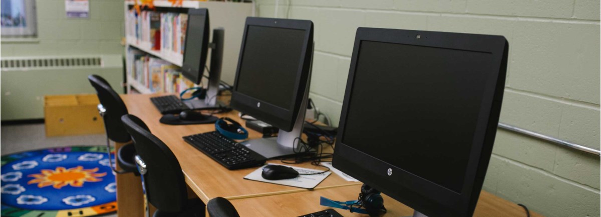 Three computers on a desk. 