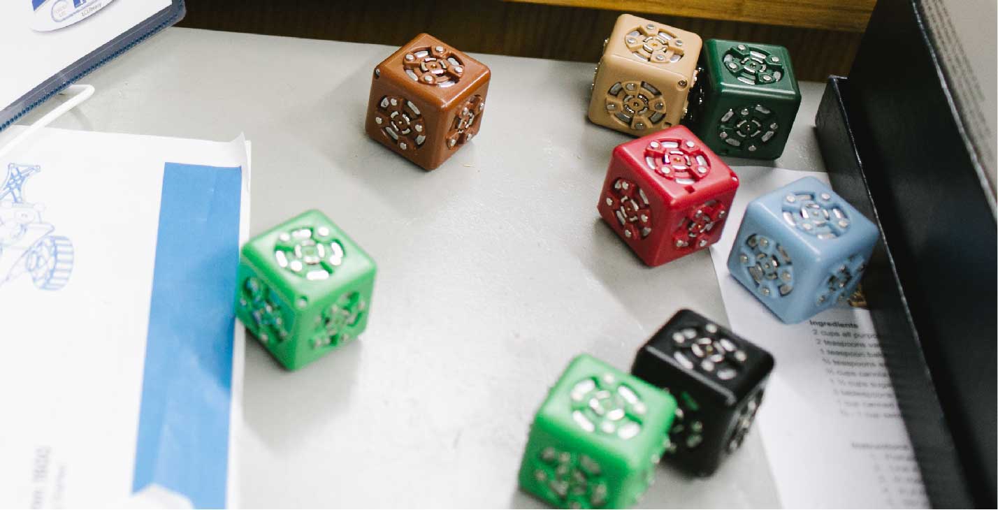 Small coloured cubes sitting on table. 