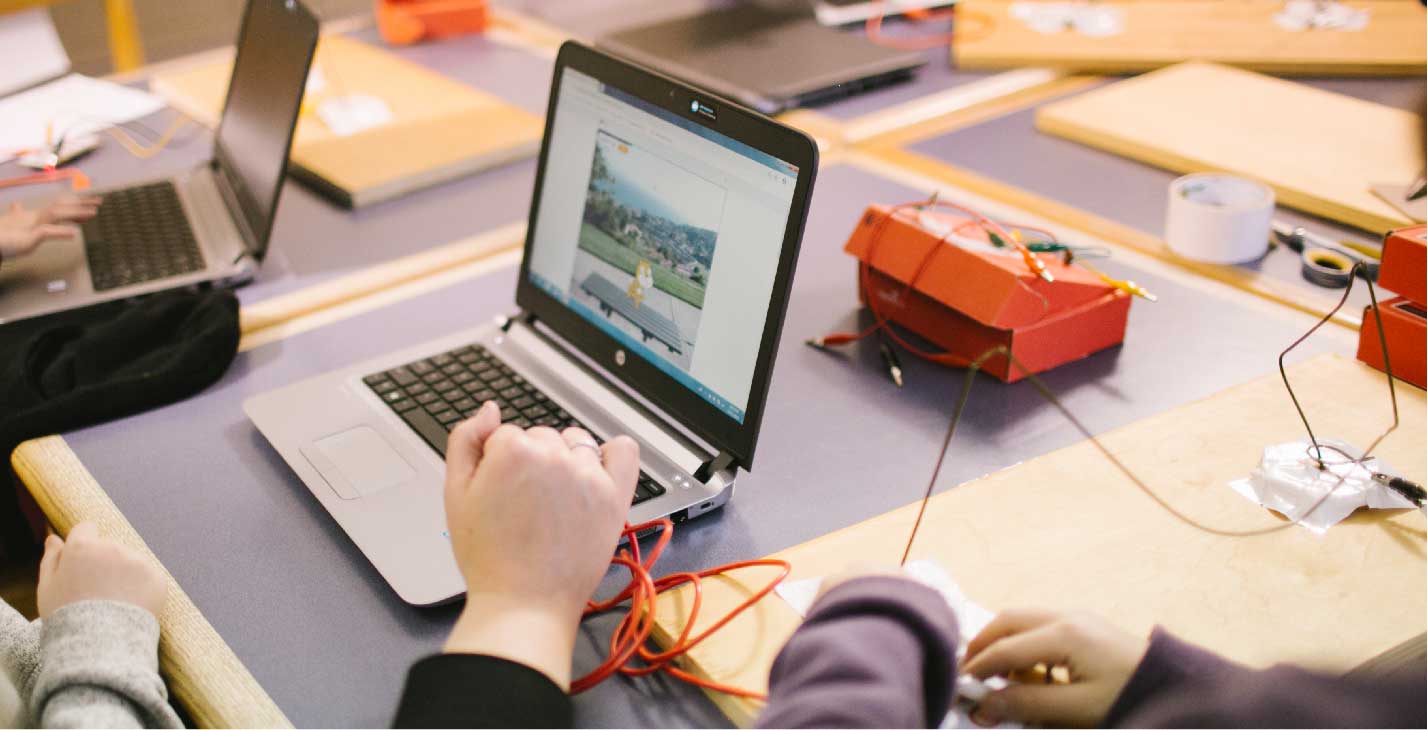 Laptop and wires on a desk.