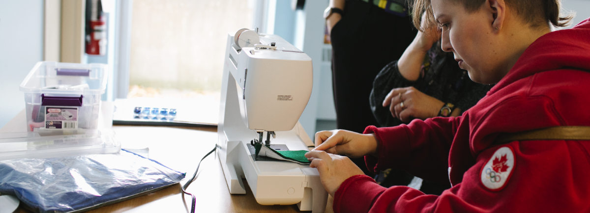 Person sewing at a sewing machine.