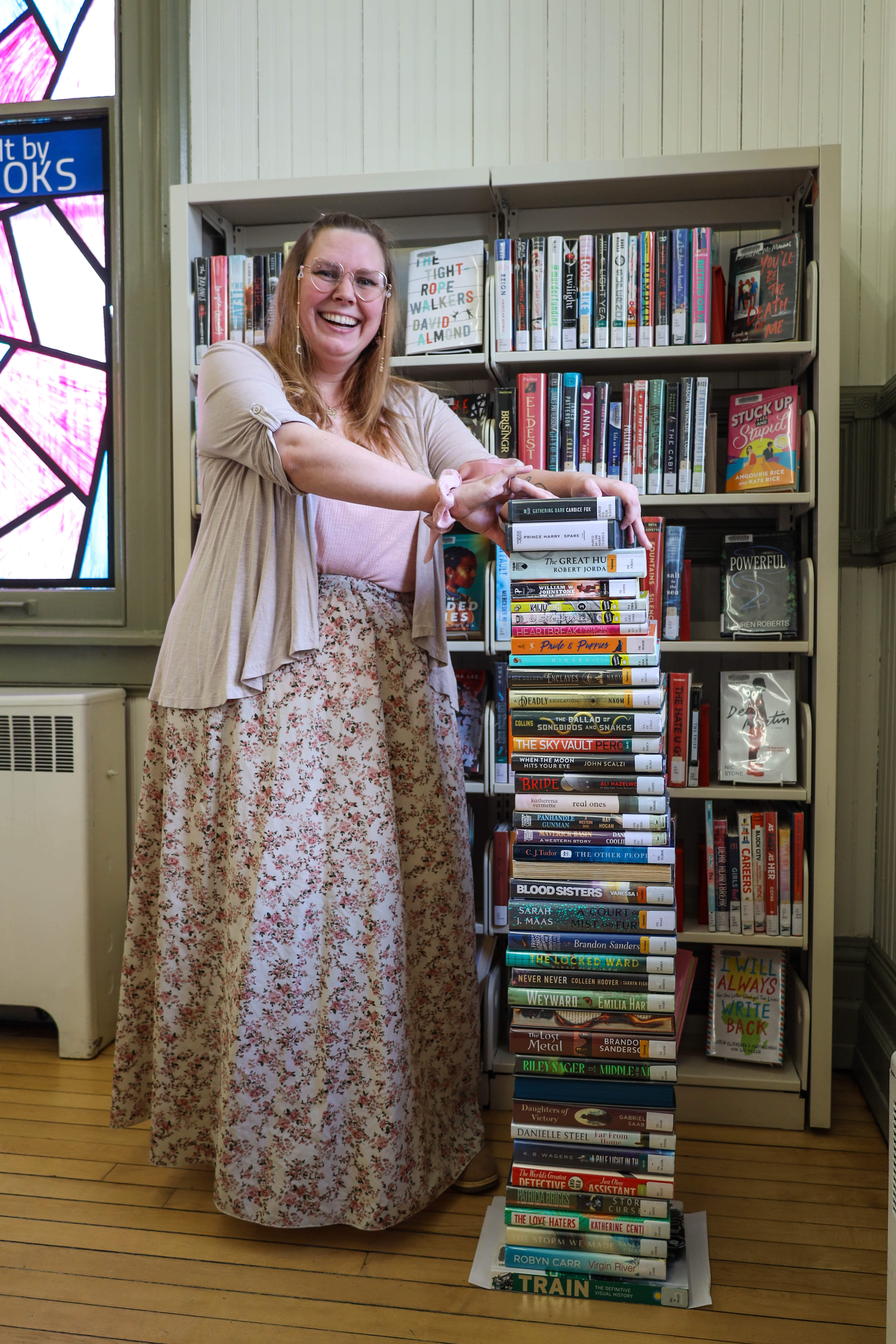 Branch assistant April Fresh stands beside 40 books at Petrolia Library. The '40 Books' reading challenge is now available to adult patrons through the Beanstack mobile app and website.