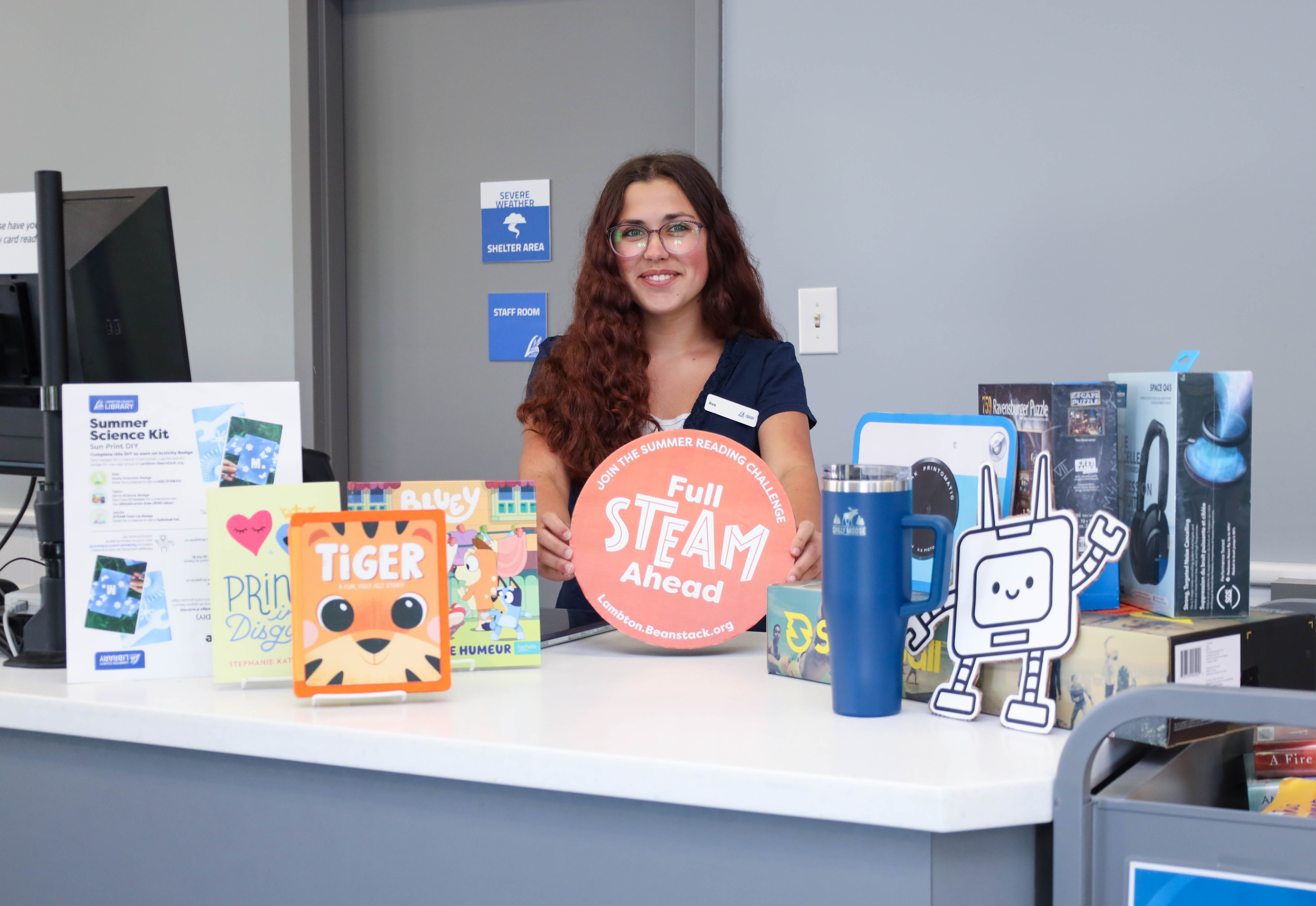 Ava Brophy, Library Page, displays Summer Reading Challenge prizes at Forest Library. 