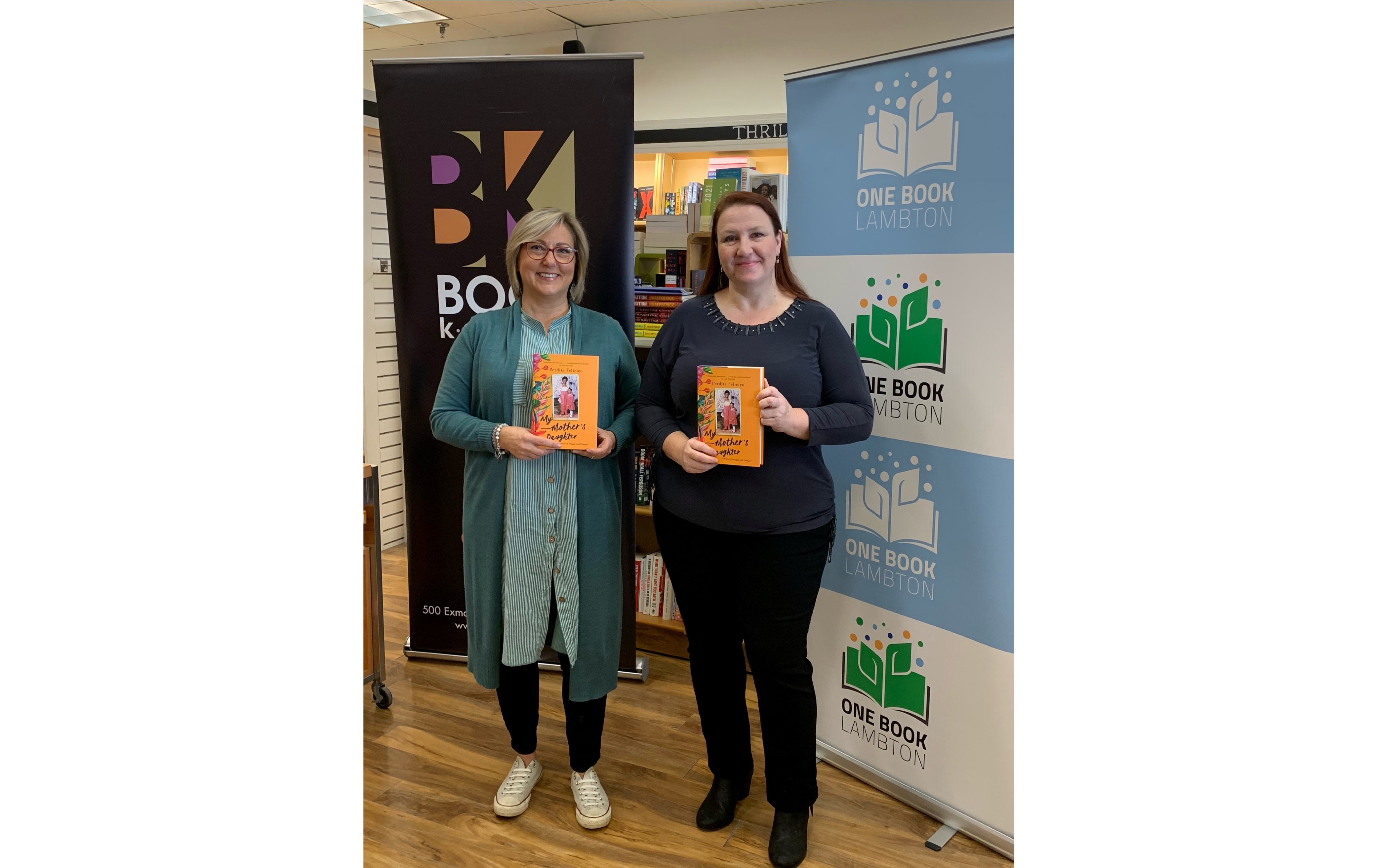 Two ladies holding a book.