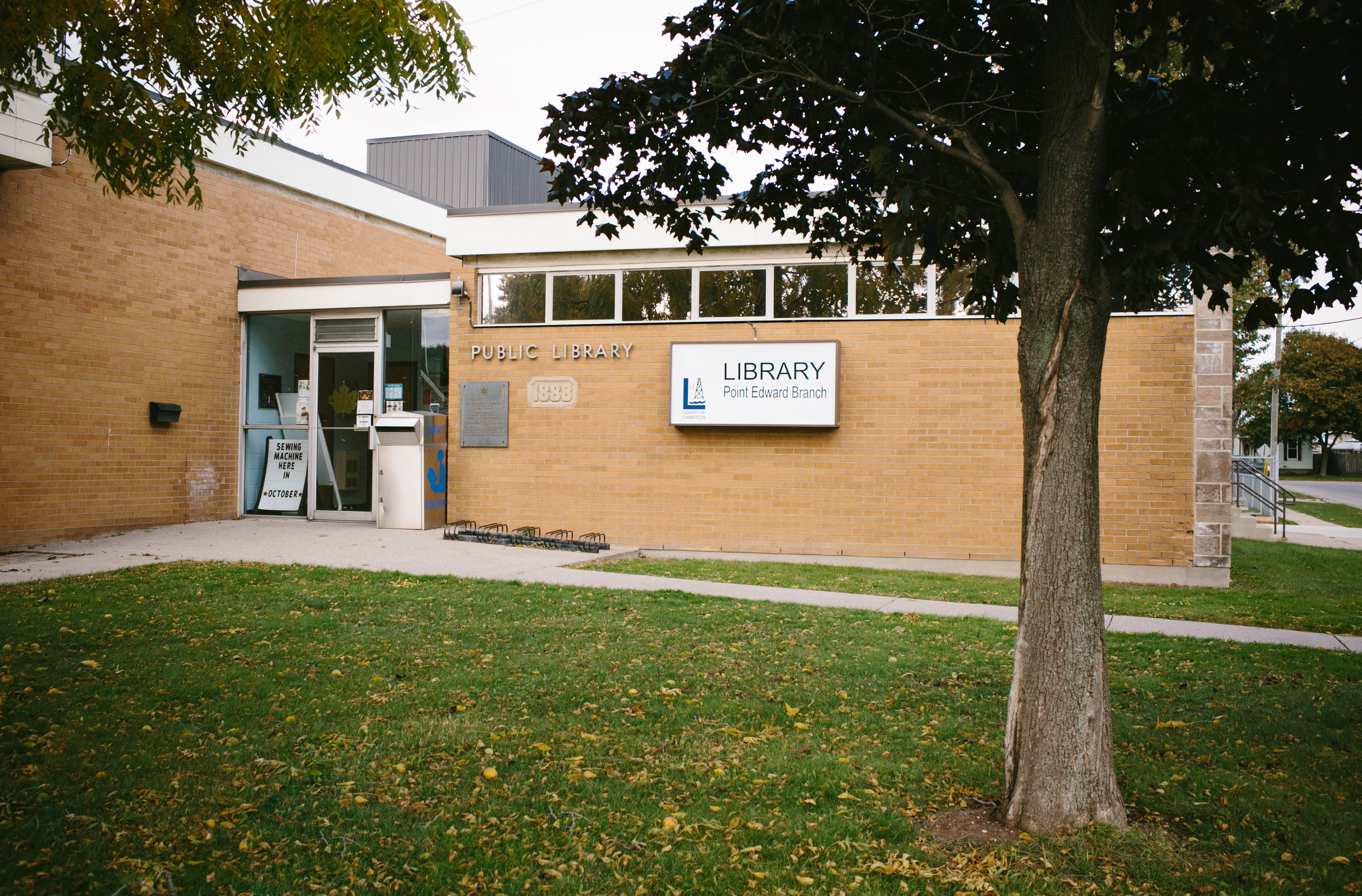 Red brick building with tree in front.