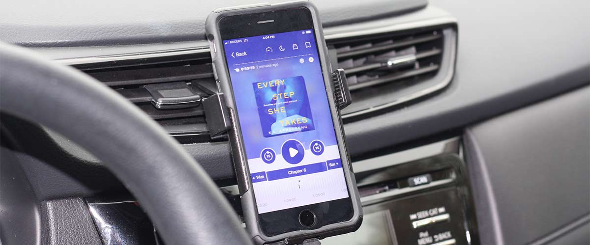 Phone on dashboard with eAudiobook playing on phone.