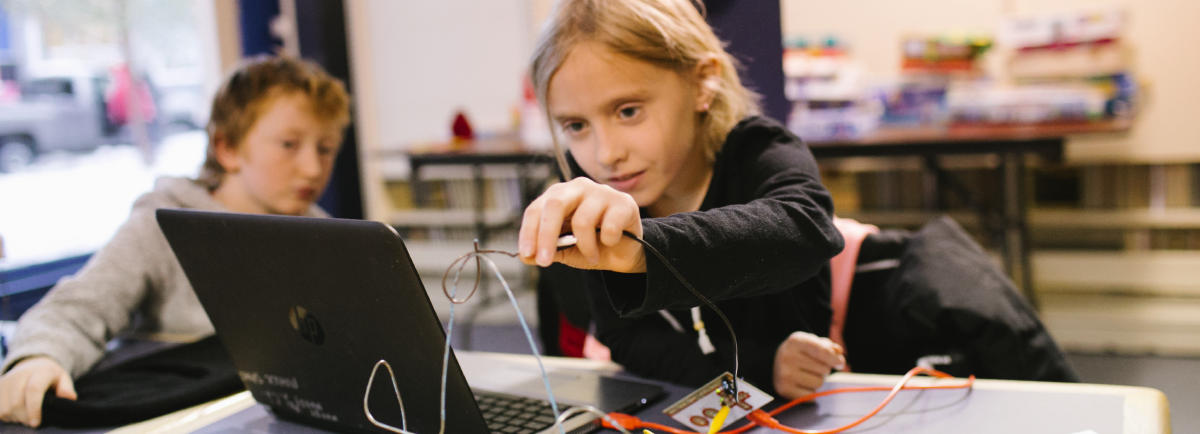 Two kids learning computer coding.