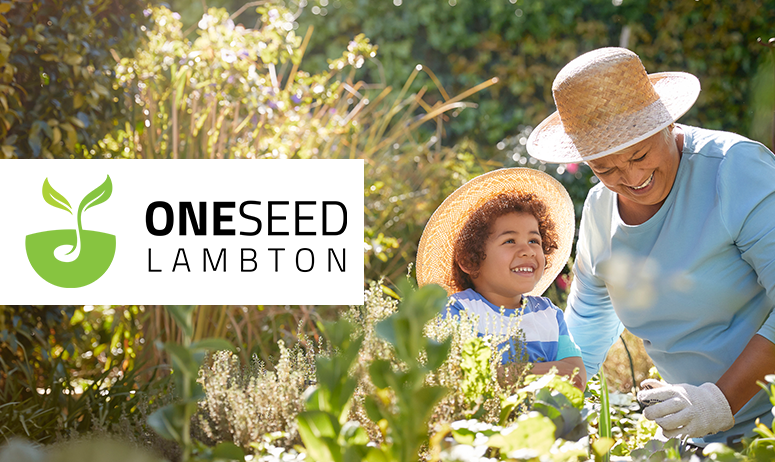Woman gardening with young child. Green banner with 'one seed lambton' logo