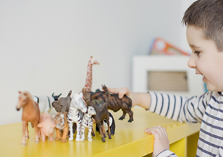 child playing with toy animals.