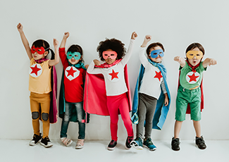 Five children dressed up like superheroes posing.