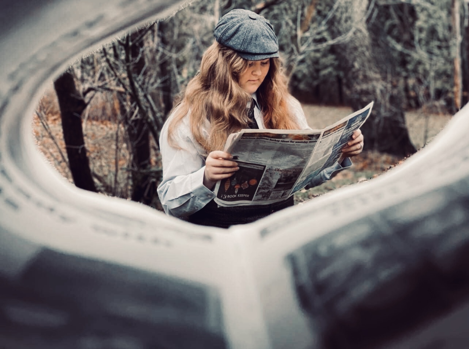 Looking through newspaper at person reading newspaper