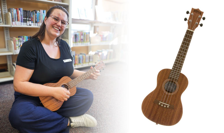 woman plays ukulele in a library