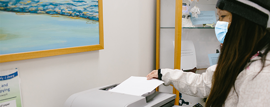 Woman printing documents at a printer. 
