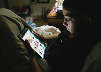 Person sitting and looking at tablet.