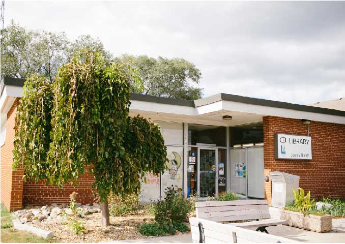 Brown brick building with tree in front. 