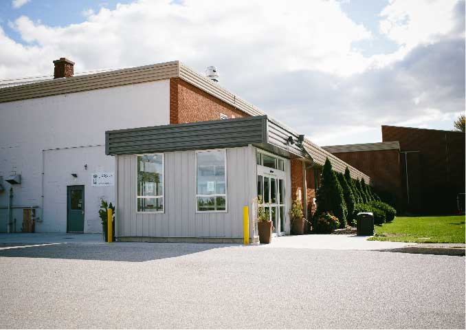 Red brick and white exterior building with grass in front. 