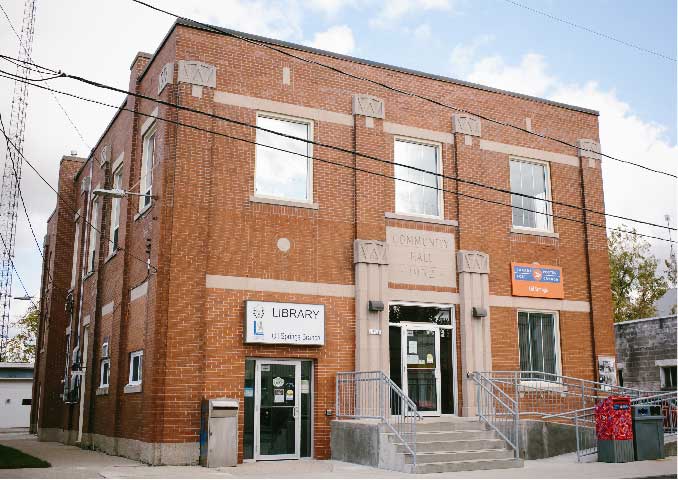 Red brick building with steps in front. 