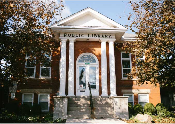 Red brick building with trees in front. 